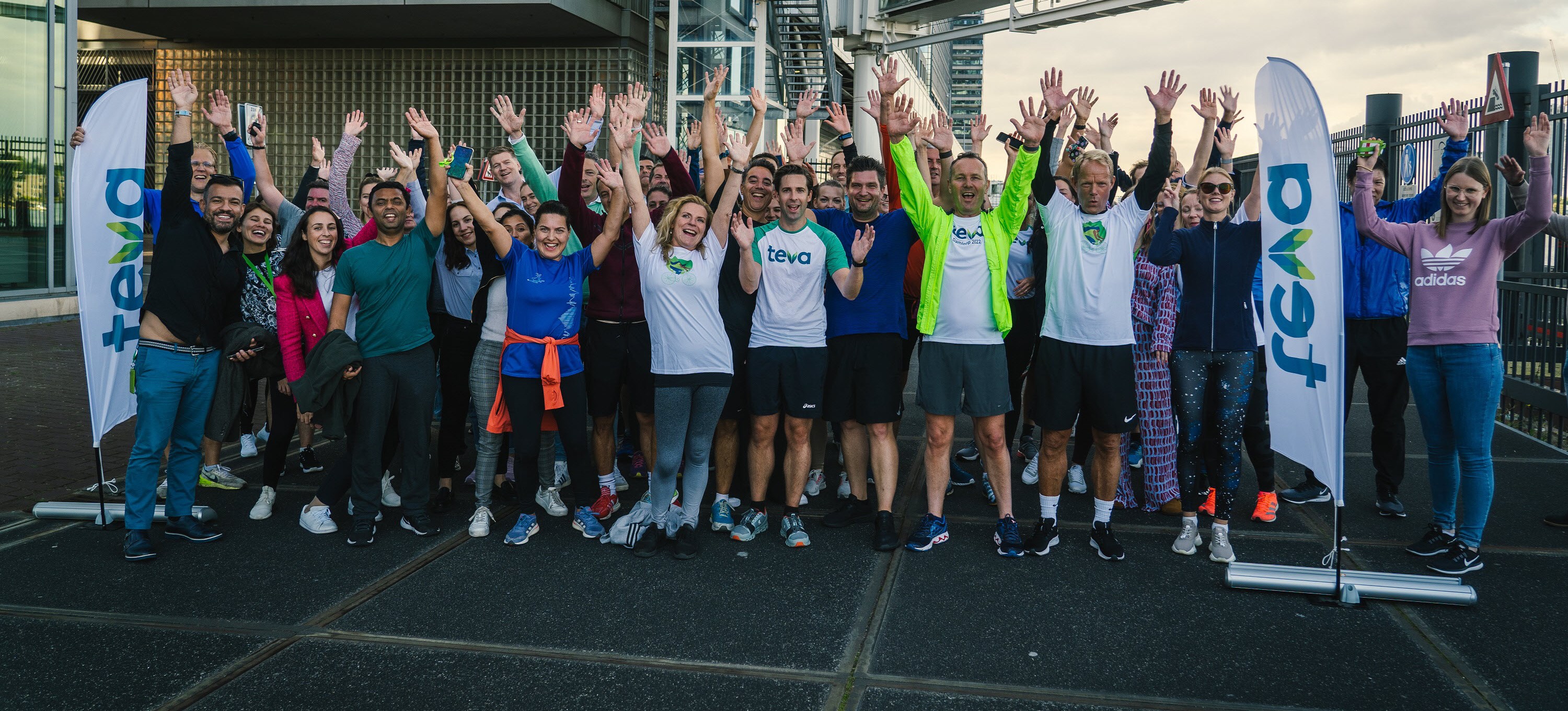 Teva employees waving hands outside in Amsterdam
